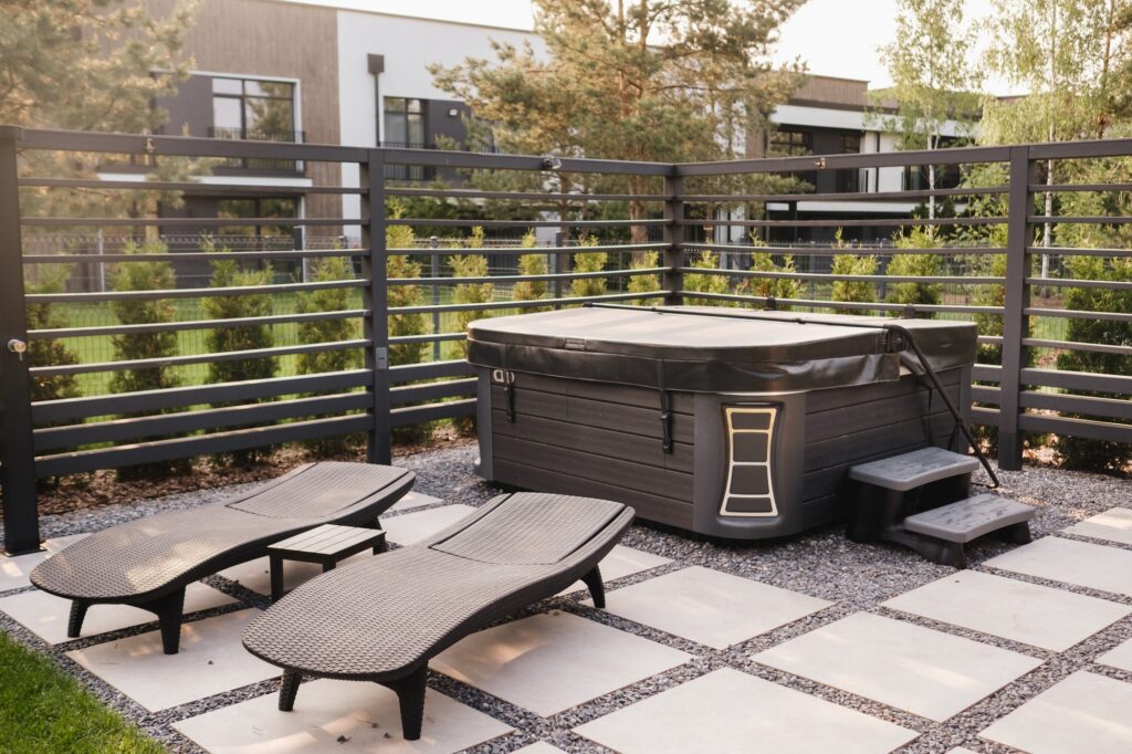 A hot tub and sun loungers in a country house. On the terrace there is a swimming pool with