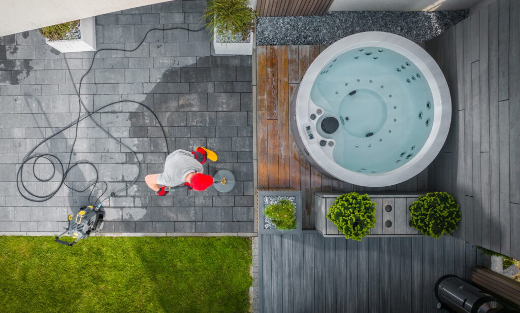 Cleaning A Modern Backyard Hot Tub and Patio Area on a Sunny Day